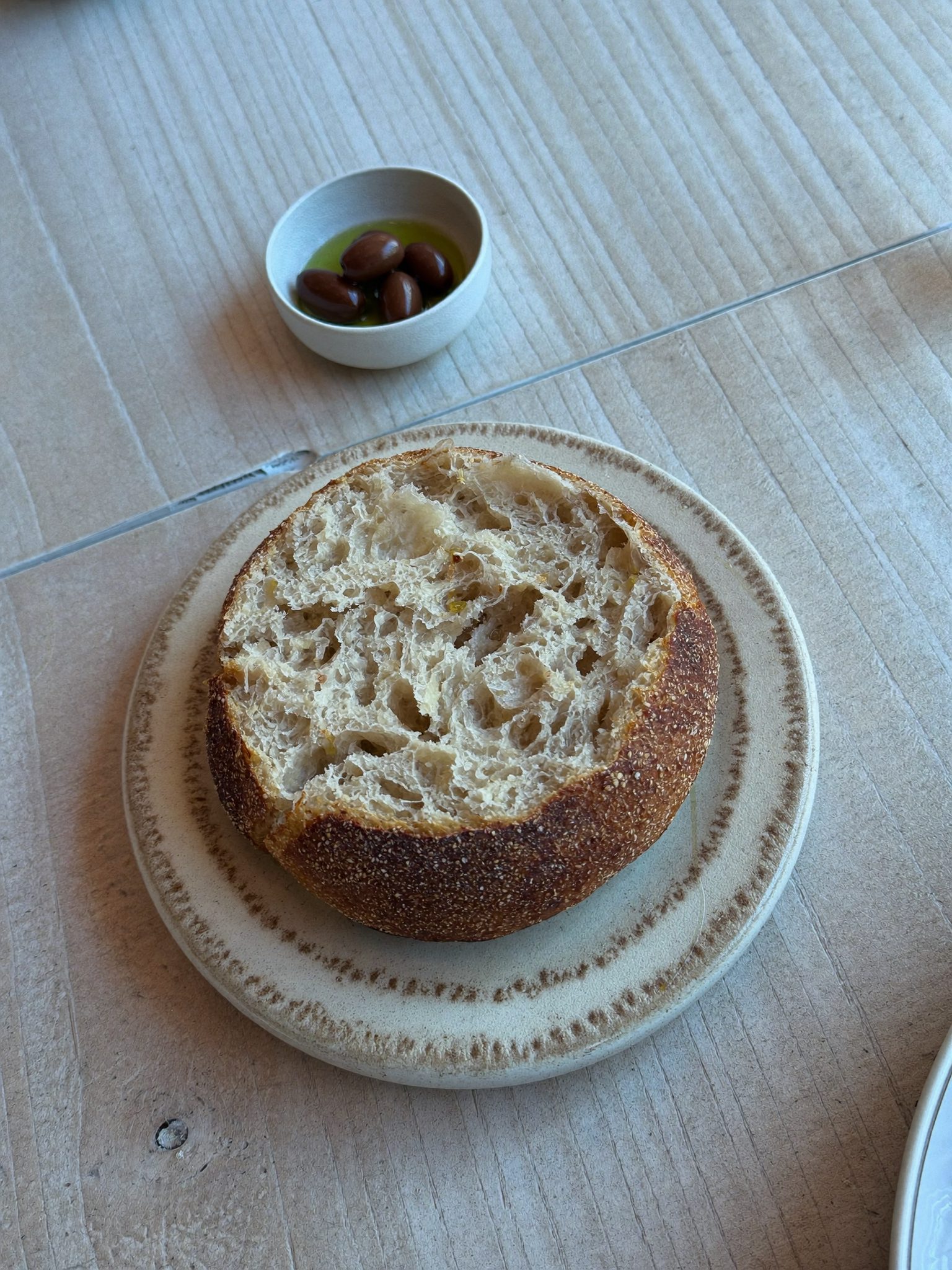 Pão caseiro com azeite sobre mesa de madeira